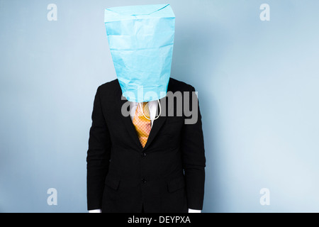 Beschämt Geschäftsmann verbirgt sein Gesicht in eine Papiertüte Stockfoto
