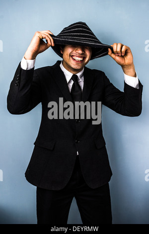 Junger Geschäftsmann ist unter seiner Wollmütze lächelnd. Stockfoto