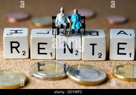 Miniaturfiguren für ein älteres Paar, sitzen auf Rechtschreibung, das Wort "Rente", Deutsch für "Rente", symbolisches Bild für Würfel Stockfoto