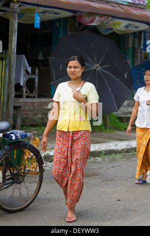 Eine Frau geht entlang der Hauptstraße in Sittwe, Birma. Stockfoto