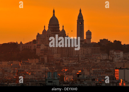 Sacré-Coeur Basilika, Basilique du Sacré Coeur gegen einen orangefarbenen Himmel in der Abenddämmerung, Paris, Ile de France, Frankreich Stockfoto