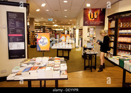 Waterstones Buchhandlung; Eine junge Frau, die im Inneren des Waterstones Buchladens, Cambridge, Großbritannien, einkauft Stockfoto