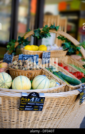 frisches Obst und Gemüse in einem großen geflochtenen Korb vor einem kleinen Geschäft in Frankreich Stockfoto