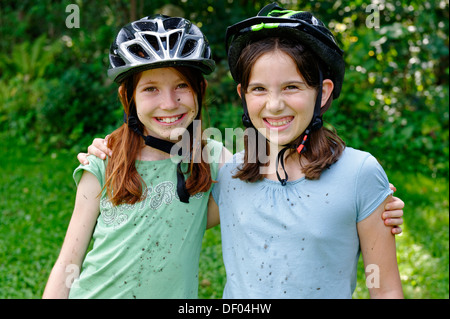 Mädchen mit Zyklus Helmen, geronnen mit Schlamm nach einer Mountainbike-tour Stockfoto