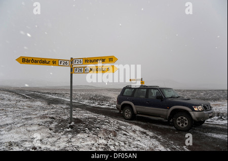 Wegweiser und Jeep auf einer verschneiten Straße in die Highlands, Sprengisandur, Island, Europa Stockfoto