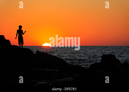 Silhouette einer Person bei Sonnenuntergang, der Strand von Las Penitas in der Nähe von Poneloya, Leon, Pacific, Nicaragua, Mittelamerika Stockfoto