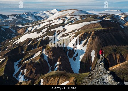 Genießen Sie den Blick aus dem Bláhnúkur Vulkan auf den schneebedeckten Rhyolith Bergen, Landmannalaugar Frau Stockfoto