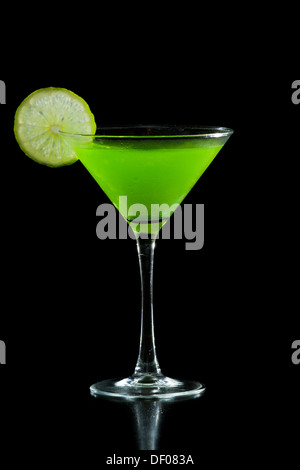 Neon grün Martini serviert auf einem schwarzen Hintergrund, garniert mit einer Limette auf der Felge Stockfoto