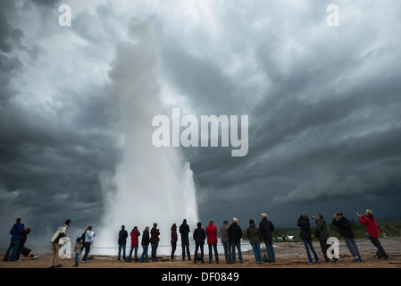 Touristen, die gerade eine Dampf- und Spalte, Stokkur Geysir im Gegenlicht Tal Haukadalur, Golden Circle, Suðurland Stockfoto