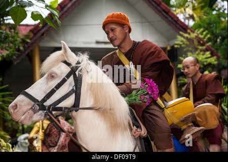 Buddhistischer Mönch auf Reiten sammeln von Almosen am Morgen, Tempel und Kloster Wat Phra Archa Thong oder Golden Horse Temple Stockfoto
