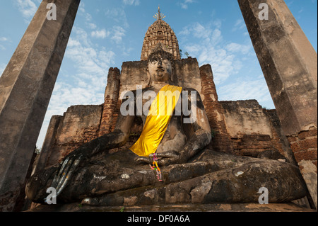 Sitzende Buddha-Statue vor einem Chedi, Tempelanlage Wat Phra Si Rattana Mahathat Chaliang Stockfoto