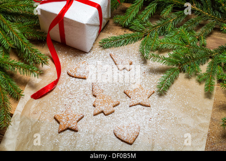 Formen der Lebkuchen auf einem Stück Papier und Puderzucker Stockfoto