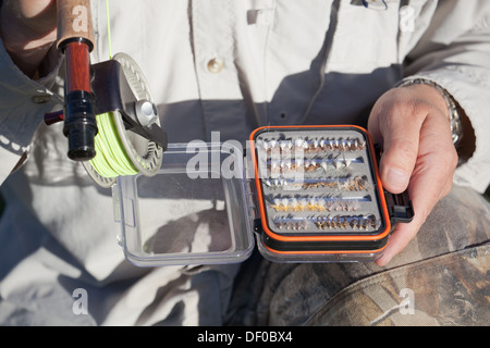 Mann, der Kasten von Fliegenfischen fliegen und Angelrute Stockfoto