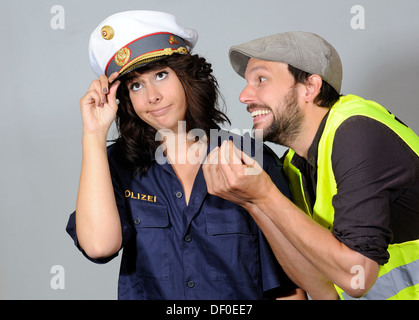 Frau, gekleidet wie ein Polizist und ein Mann, ein symbolisches Bild für eine Aufschlüsselung Stockfoto