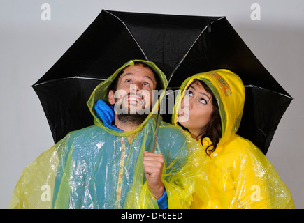 Mann und Frau stehen unter einem Regenschirm, symbolisches Bild z. B. Wetterbericht Stockfoto