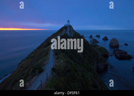 Sonnenaufgang vor der pazifischen Küste an der Nugget Point Lighthouse, südöstlichen Otago, Südinsel von Neuseeland Stockfoto