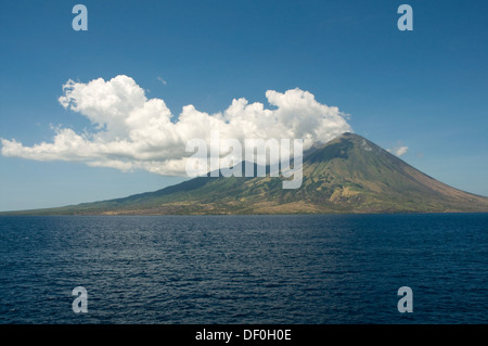 Indonesien, Insel Sumbawa, Vulkan mit Wolken und blauer Himmel im Bild aus dem Meer Stockfoto