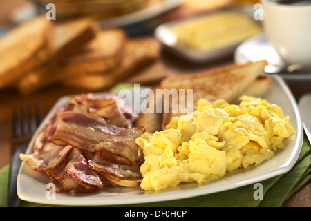 Gebratener Speck und Rührei mit Toast-Brot in den Rücken (selektiven Fokus, Fokus in der Mitte das Rührei) Stockfoto