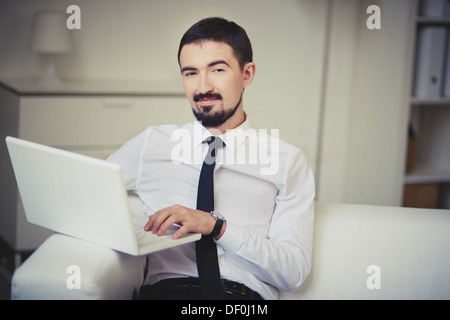 Porträt des noblen Mann mit Laptop, Blick in die Kamera Stockfoto