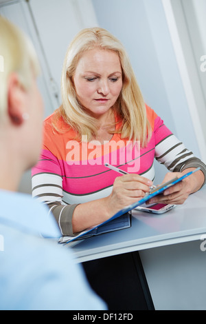 Ältere Frau medizinische Formular an der Rezeption der zahnärztlichen Praxis Stockfoto