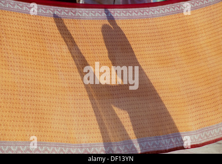 Schatten einer Frau trocknen ihr Sari nach dem Baden im Fluss Ganges, Triveni Ghat, Rishikesh, Uttarakhand, Indien Stockfoto