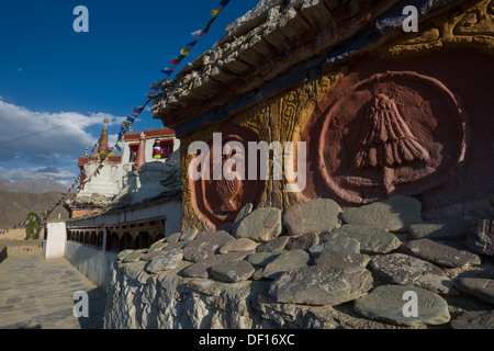 Geschnitzte Mani-Steinen, Chortons und Gebetsmühlen an der Außenseite des Lamayuru Gompa, (Ladakh) Jammu & Kaschmir, Indien Stockfoto