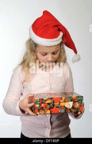 Berlin, Deutschland, das kleine Mädchen mit Weihnachts-Geschenk und Nikolausmuetze Stockfoto