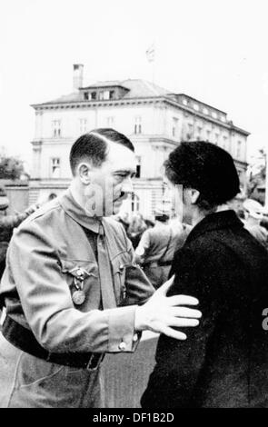 Das Bild der Nazi-Propaganda! Shows Adolf Hitler anlässlich des Jubiläums der Bierhalle Putsch vom 9. November 1923 in München am 9. November 1935. Hier spricht er mit der Frau einer Person, die während des marsches zur Feldherrenhalle 1923 getötet wurde. Im Hintergrund das Braune Haus (Brown House). Fotoarchiv für Zeitgeschichte Stockfoto