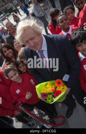 London, UK. 26. September 2013. Boris Johnson stellt mit Blumen, die ihm durch die Schülerinnen und Schüler bei der feierlichen Eröffnung des Kings Cross Platz gegeben nach der Station £550m Sanierung. Bildnachweis: Paul Davey/Alamy Live-Nachrichten Stockfoto