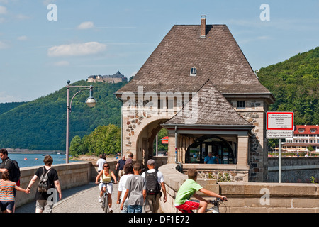 Besucher genießen Sommersonne auf der Brüstung der Eder Damm, Deutschland. Schloss Waldeck im Hintergrund. Stockfoto