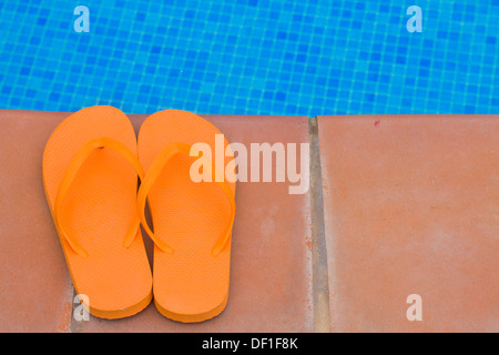 Flip-Flops auf Poolseite Stockfoto