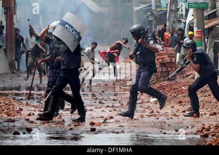 Narayanganj, Bangladesch. 26 Sep, 2013. Bangladeshi Polizei Beamten als markante Textilarbeiterinnen Steine während eines Protestes in Narayanganj am 26. September 2013 zu werfen. Die meisten bangladesch Textilfabriken haben nach fünf Tagen heftige Proteste über Lohnerhöhungen für die Textilarbeiter wiedereröffnet, nachdem die Regierung auf die Unruhen zu Crack' mit aller Kraft. Stockfoto