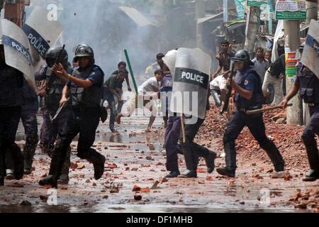 Narayanganj, Bangladesch. 26 Sep, 2013. Bangladeshi Polizei Beamten als markante Textilarbeiterinnen Steine während eines Protestes in Narayanganj am 26. September 2013 zu werfen. Die meisten bangladesch Textilfabriken haben nach fünf Tagen heftige Proteste über Lohnerhöhungen für die Textilarbeiter wiedereröffnet, nachdem die Regierung auf die Unruhen zu Crack' mit aller Kraft. Stockfoto