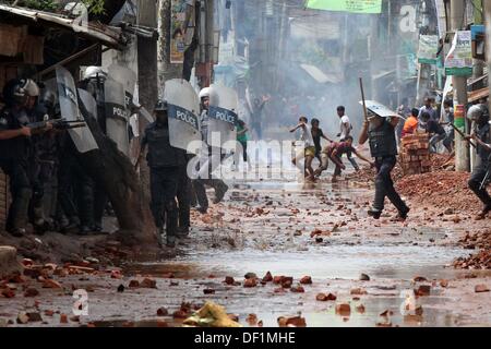 Narayanganj, Bangladesch. 26 Sep, 2013. Bangladeshi Polizei Beamten als markante Textilarbeiterinnen Steine während eines Protestes in Narayanganj am 26. September 2013 zu werfen. Die meisten bangladesch Textilfabriken haben nach fünf Tagen heftige Proteste über Lohnerhöhungen für die Textilarbeiter wiedereröffnet, nachdem die Regierung auf die Unruhen zu Crack' mit aller Kraft. Stockfoto