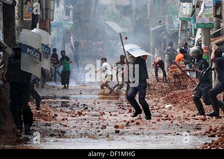 Narayanganj, Bangladesch. 26 Sep, 2013. Bangladeshi Polizei Beamten als markante Textilarbeiterinnen Steine während eines Protestes in Narayanganj am 26. September 2013 zu werfen. Die meisten bangladesch Textilfabriken haben nach fünf Tagen heftige Proteste über Lohnerhöhungen für die Textilarbeiter wiedereröffnet, nachdem die Regierung auf die Unruhen zu Crack' mit aller Kraft. Stockfoto