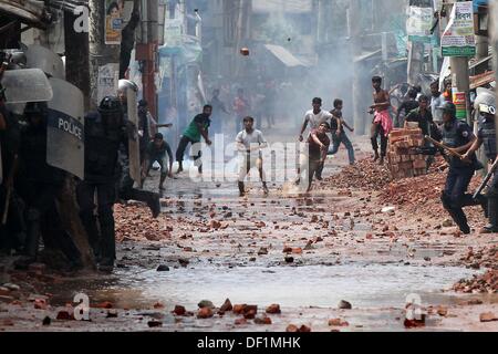 Narayanganj, Bangladesch. 26 Sep, 2013. Bangladeshi Polizei Beamten als markante Textilarbeiterinnen Steine während eines Protestes in Narayanganj am 26. September 2013 zu werfen. Die meisten bangladesch Textilfabriken haben nach fünf Tagen heftige Proteste über Lohnerhöhungen für die Textilarbeiter wiedereröffnet, nachdem die Regierung auf die Unruhen zu Crack' mit aller Kraft. Stockfoto