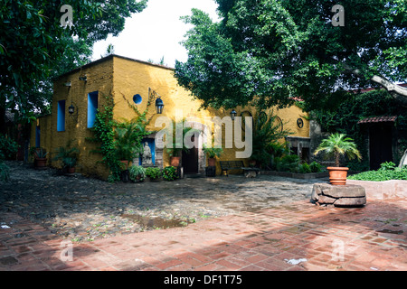 Lässige Innenhof, rote Pflasterklinker und ein helles Gelb Stuck Gebäude. Stockfoto