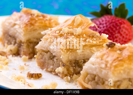 Drei Stücke von goldener Farbe Baklava mit Walnüssen und Erdbeere, Makroaufnahme garniert Stockfoto