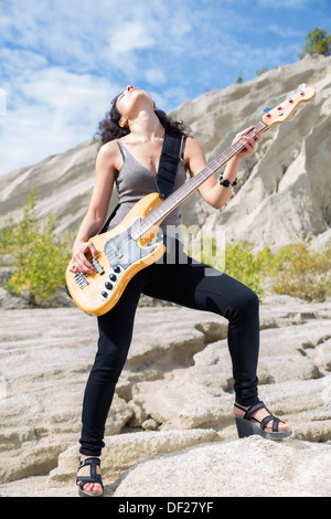 Frau fühle mich großartig auf gelben Bass-Gitarre spielen Stockfoto