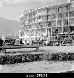 Historisches Bild aus den 1950er Jahren von J Allan Cash eines halbkreisförmigen Hotelgebäudes und Verkehrs, Kabul, Afghanistan. Die 1950er- und 1960er-Jahre waren eine relativ friedliche Zeit für das Land, in dem eine Reihe neuer, moderner Gebäude errichtet wurden, wie auf dem Bild zu sehen ist, und die Bemühungen, das Land zu modernisieren und eine offenere, wohlhabendere Gesellschaft zu schaffen. Dies endete in den 1970er Jahren mit Invasionen, Staatsstreichs und Bürgerkriegen. Stockfoto