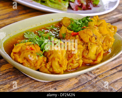 sechs kleine gedünstete Hühnerkeule in roter sauce Stockfoto