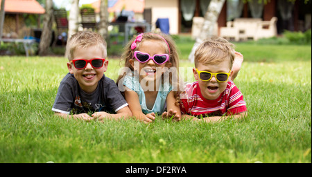 Glücklich lachende Kinder auf der Wiese liegend Stockfoto