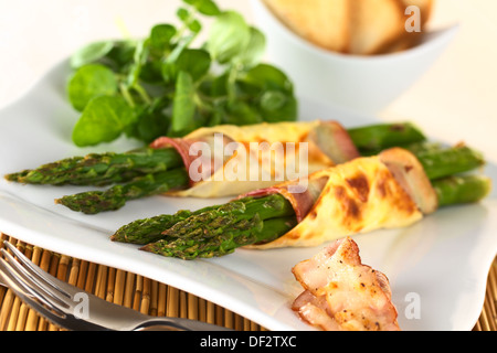 Gebackene Grünspargel eingewickelt in Speck und Wan-Tan-Teig (selektiven Fokus, Fokus auf die Spargelspitzen des ersten Bundles) Stockfoto