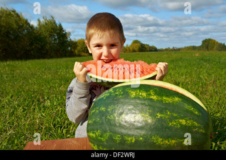 Lächelnde Knabe Wassermelone im Freien zu essen Stockfoto