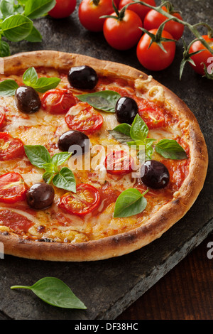 rustikale italienische Pizza mit Mozzarella, Käse und Basilikum Blätter Stockfoto