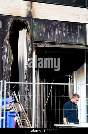 Bauarbeiter stehen vor der Baustelle des Kö-Bogen nach einem Brand in Düsseldorf, 27. September 2013. Ein Feuer in der fast abgeschlossenen Gebäudekomplex eines luxuriösen shopping-Arkade und Einkaufsstraße verursachte erhebliche Schäden an den Standort. Die prestigeträchtige Anlage eröffnet am 17. Oktober 2013. Foto: FEDERICO GAMBARINI Stockfoto