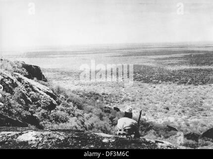 Das Bild der Nazi-Propaganda! Darstellung der italienischen Kolonialsoldaten, die an der Front in Kenia kämpften, veröffentlicht am 7. Februar 1941. Ort unbekannt. Der Text auf der Rückseite des Bildes lautet: "Auf der kenianischen Vorderseite. An der kenianischen Front (italienisch Ostafrika) entfaltet sich ein typischer Kolonialkrieg. Im Vordergrund ein 'askari'. Fotoarchiv für Zeitgeschichte Stockfoto