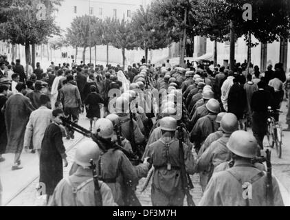 Das Bild der Nazi-Propaganda! Zeigt deutsche Soldaten der Wehrmacht, die durch Tunis, Tunesien, marschieren, veröffentlicht am 3. Februar 1942. Fotoarchiv für Zeitgeschichte Stockfoto