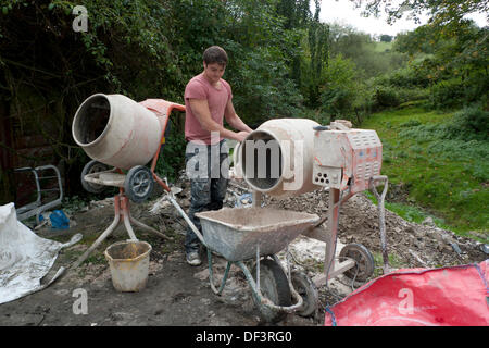 Llanwrda, Wales UK Freitag, 27. September 2013. 22-jährige reinigt alte Carl Evans von Ammanford, einen voll qualifizierten Stuckateur einen Betonmischer von Hanf Kalkputz, die er bei der Renovierung einer traditionellen walisischen Scheune, Innenwände verwandt hat. Carl ist ein Mitarbeiter der Spezialist Kalk Gipser und Eco-Builder Neil Plume von Grand(ish) Designs, die Services in Carmarthenshire, Süd, West und Mitte Wales UK bietet. Grand(ish) Designs verwenden grüne nachhaltigere Materialien auf traditionelle und neue Gebäude. Kathy DeWitt/Alamy Live-Nachrichten Stockfoto