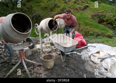 Llanwrda, Wales UK Fr., 27. September 2013. 22 jährige Carl Evans aus Ammanford, ein vollständig qualifizierter Putzer, reinigt, einem betonmischer von Kalk Hanf Gips, die er für die Innenwände während der Renovierung eines traditionellen walisischen Scheune wurde. Carl ist ein Mitarbeiter der Spezialist Kalk Gipser und Eco-builder Neil plume von 'Grand (ish) Designs', die Dienstleistungen in Carmarthenshire, Süd, West und Mitte von Wales UK bietet. Grand (ish) Designs verwenden grüne nachhaltige Materialien auf den traditionellen und neuen Gebäuden. Kathy deWitt/Alamy leben Nachrichten Stockfoto